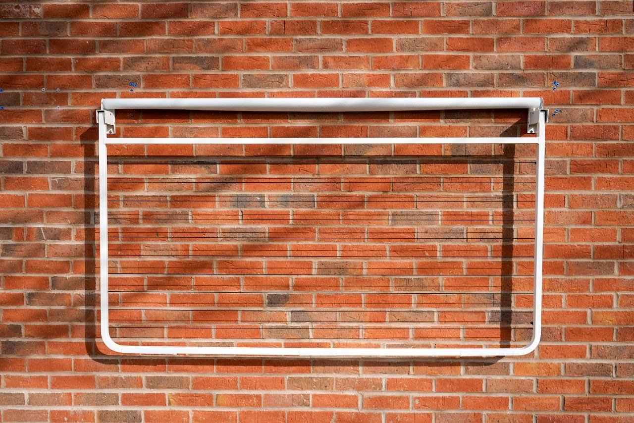 Janro Wall Mounted Washing Line With Retractable Cover in use Outdoors.